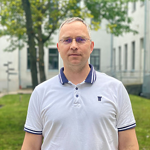 Dr. Rimantas Rauleckas stands outside the university building wearing a light gray shirt. He is a senior researcher and associate professor of the project.